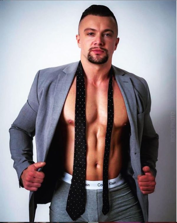 How Strippers and 2026 Olympic Figure Skaters Master the Same Body Skills Muscular man in suit with tie